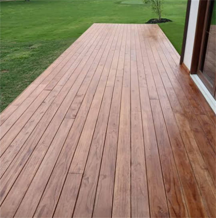 Newly installed Brazilian teak (Ipe) wooden backyard deck adjacent to home with green lawn