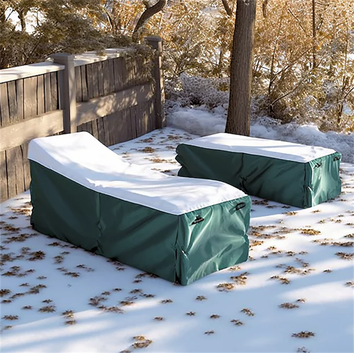 Weatherproof green outdoor lounge chair protective covers shielding patio furniture in snowy Alaskan backyard