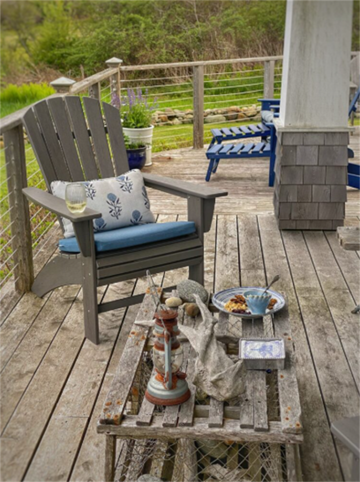 Residential Maine seaside wooden deck with aged tannin discoloration and rustic patio furniture