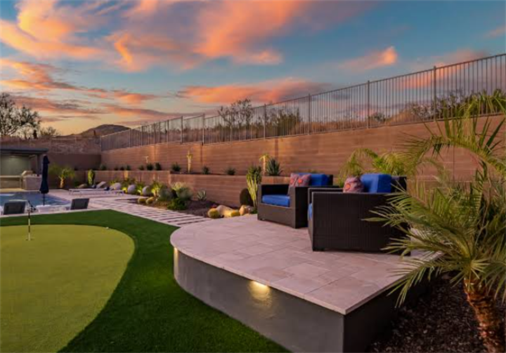 Phoenix luxury backyard with rammed earth retaining wall, patio, putting green and swimming pool