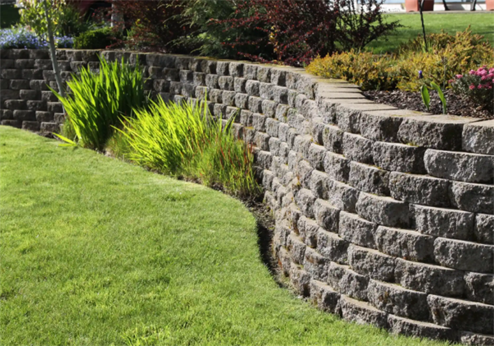 Mature curved retaining wall with landscaping, stable structure built for Minnesota frost line conditions