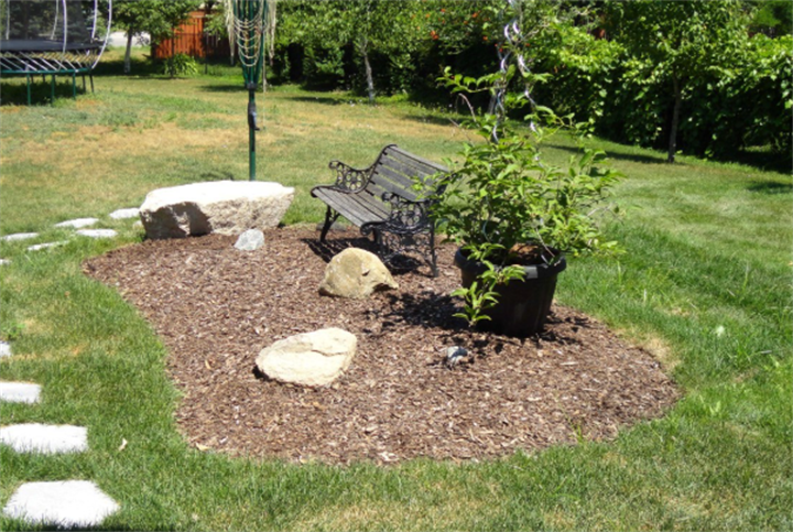 Simple mulch and rock seating area built over a residential septic mound