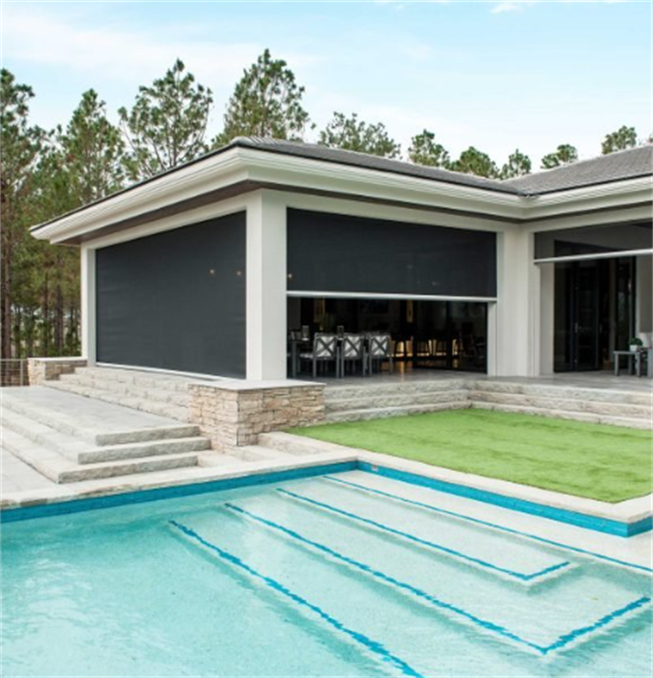 Modern poolside home fitted with motorized roll-down patio screens for an open-air screened living space